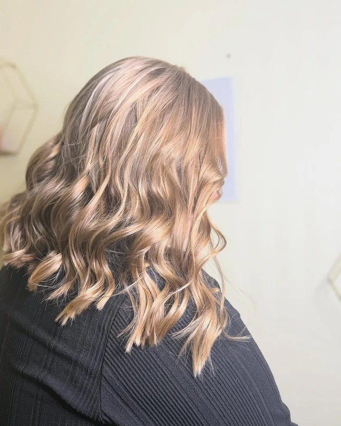 Balayage blond ondulé réalisé chez Coiff Evolution, salon de coiffure à Saint-Pol-sur-Mer