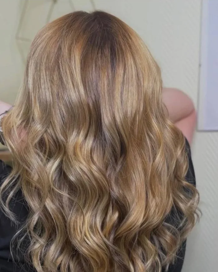 Balayage blond ondulé vu de dos, Coiff Evolution à Saint-Pol-sur-Mer